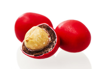 Peanuts covered with red glaze on a white background