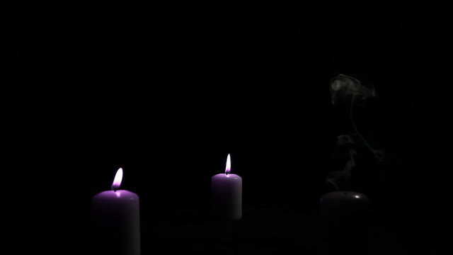 Three candles with a pink flame
