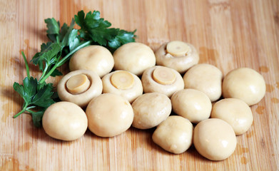 Whole champignons with parsley on the chopping board