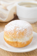 sweet donut on a plate and cup of coffee closeup