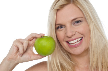 Closeup shot of a cheerful woman holding an apple