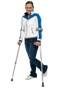 Woman walking with the support of crutches