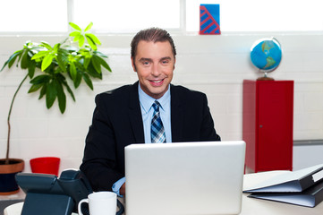 Corporate leader sitting in front of his laptop