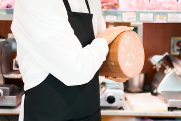 Shopkeeper showing bologna in an italian grocery store © Minerva Studio