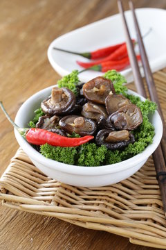 Chinese fried shiitake mushrooms in a bowl with parsley