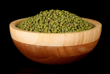 mung beans in wooden bowl isolated on black