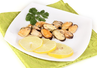 Snack of mussels and lemon on plate isolated on white