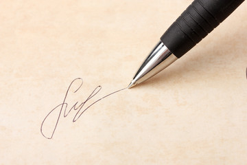 Closeup of signature (fake, not real) and pen, on old paper