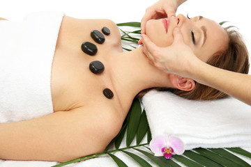 Portrait of beautiful woman with spa stones taking head massage