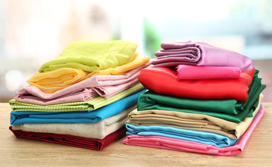 heap of cloth fabrics on wooden table