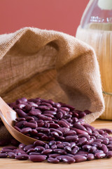 Red beans in a wooden spoon and bag