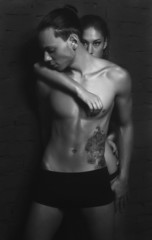 Naklejka premium Handsome fitness sports man with a gilr posing at the studio