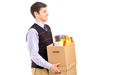A smiling male walking with boxes moving into a new home