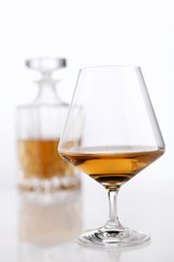 bottle and glass of brandy on a white background