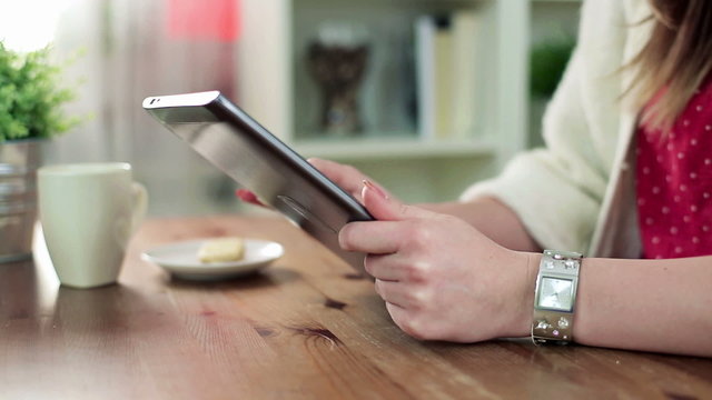 Female hands with tablet computer by the table