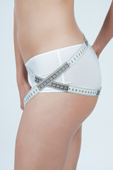 femme mesurant ses hanches en boxer blanc