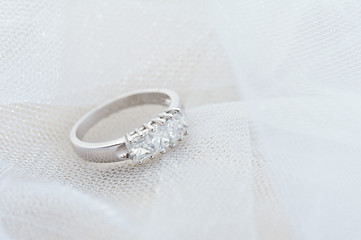 Engagement ring on white veil