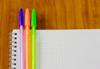 school belonging, notebook and three pens