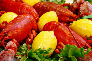 sea food made of lobsters, lemons and green salad
