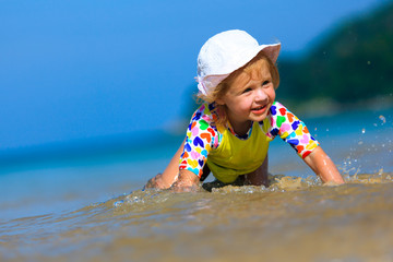 Funny Little girl playing on the beach