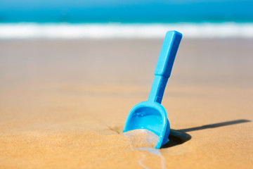Small shovel in the sand on the beach