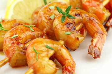 Glazed shrimp skewers with thyme and lemon closeup