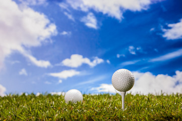 Golf balls, green grass, clouds background