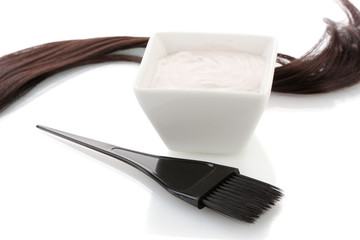 Bowl with hair dye and black brush on white background close-up