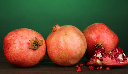 Ripe pomegranates on green background