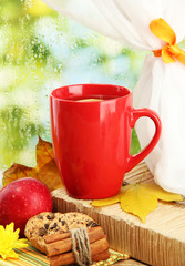 cup of hot tea and autumn leaves, on rain background