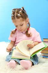 cute little girl with colorful books, on blue background