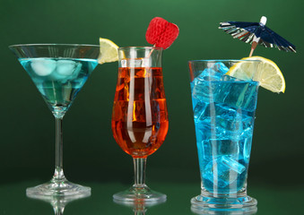 Alcoholic cocktails with ice on darck green background