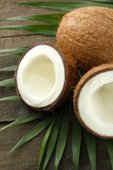 Coconut with leaves, on grey wooden background