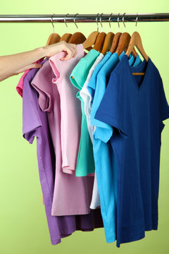 Variety of casual shirts on wooden hangers,on green background