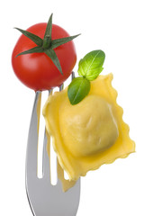 ravioli pasta tomato and basil on fork against white background