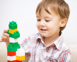 Boy is playing with building blocks