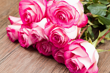 Beautiful pink roses on wooden background