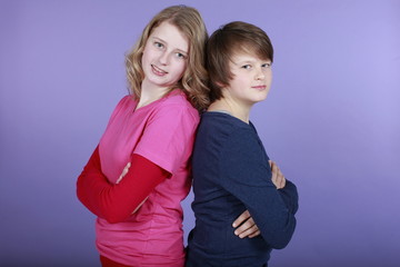 Bruder und Schwester lehnen Rücken an Rücken aneinander