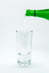 water pouring into glass on white background