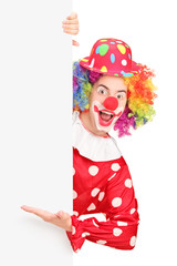 A male clown gesturing on a blank panel
