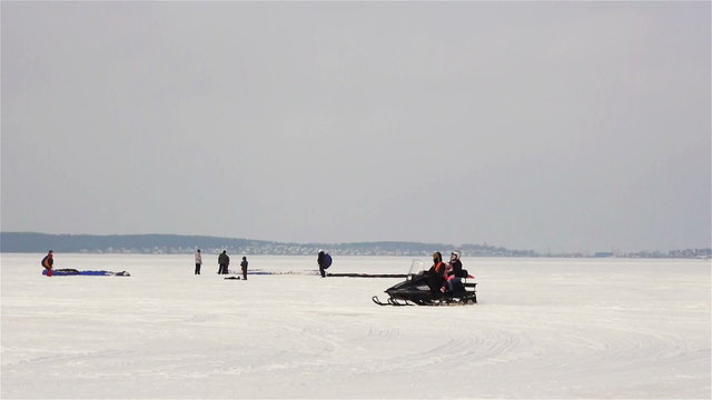 Riding motosledge snowmobile on winter lake