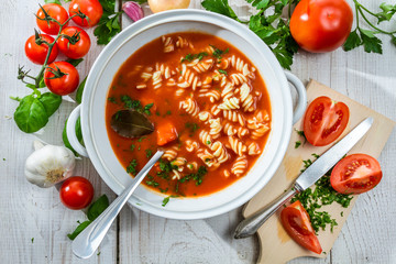 Vase with tomato soup and fresh vegetables