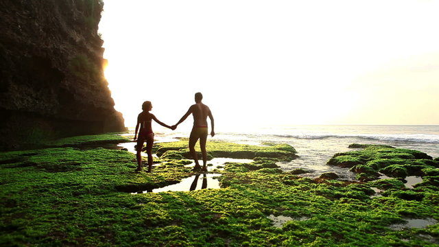 Cheerful couple in love walking on Bali lagoon