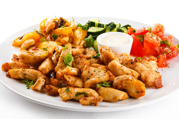 Grilled meat and vegetables on white background