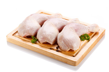 Raw chicken legs on cutting board on white background