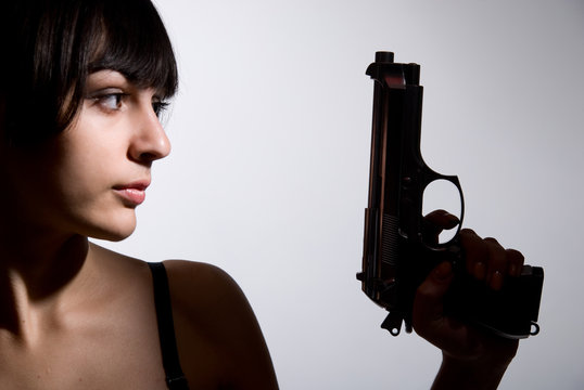 Close-up portrait of sexy woman with gun