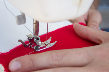 Hands of tailor sewing clothes