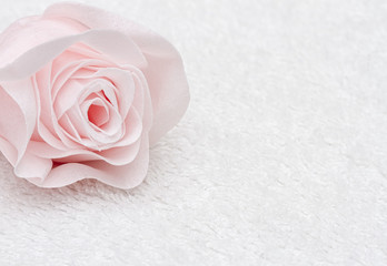 Pink artificial bath rose on white towel