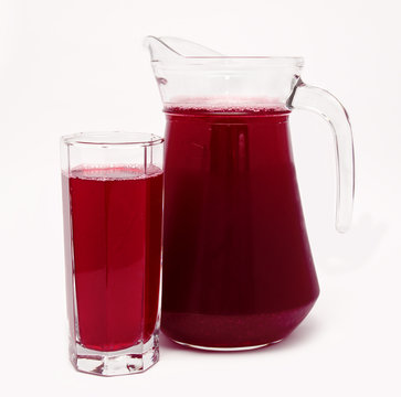 Pitcher and glass of red fruit juice isolated on white