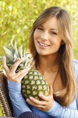 Glückliche Frau mit einer Ananas auf der Terrasse